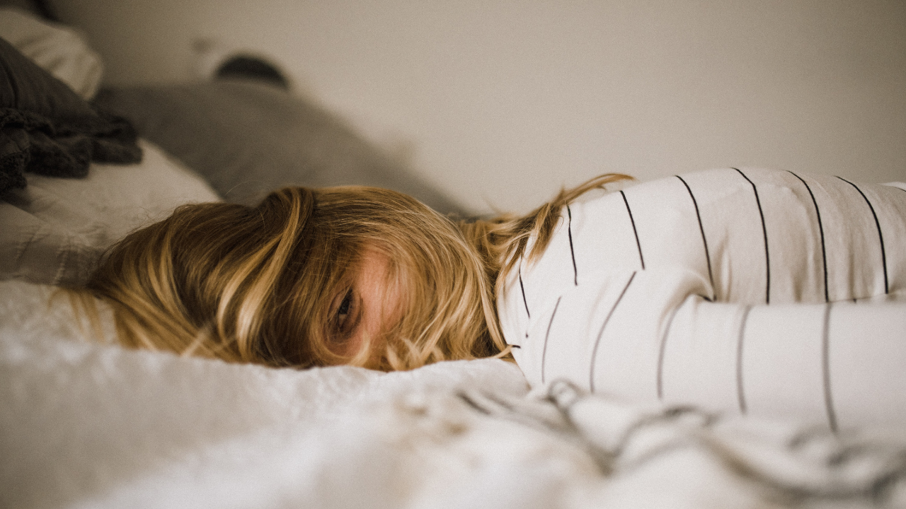 Girl laying in bed with her face down